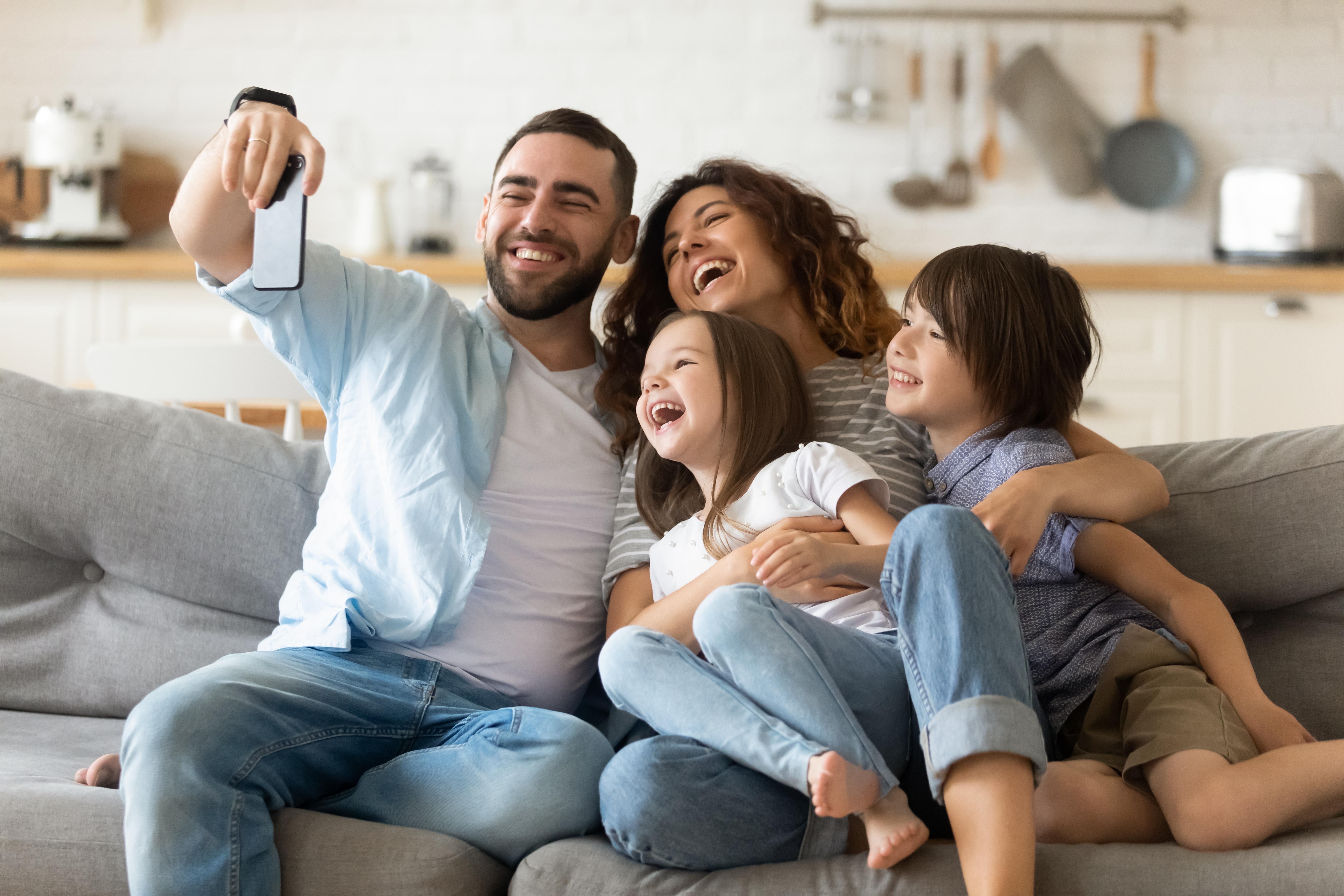 Man investing in cryptocurrency takes selfie with family
